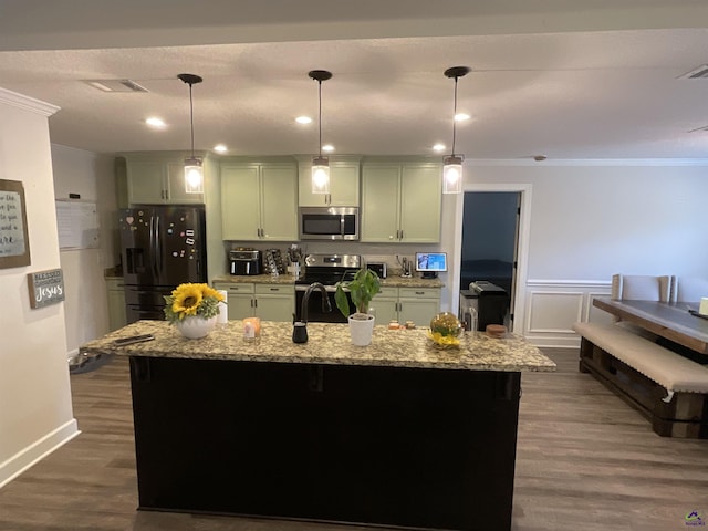 kitchen with light stone counters, dark wood-style floors, a center island with sink, appliances with stainless steel finishes, and crown molding