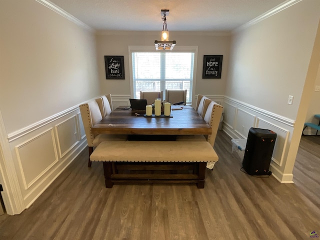 dining room featuring a chandelier, a wainscoted wall, crown molding, and wood finished floors