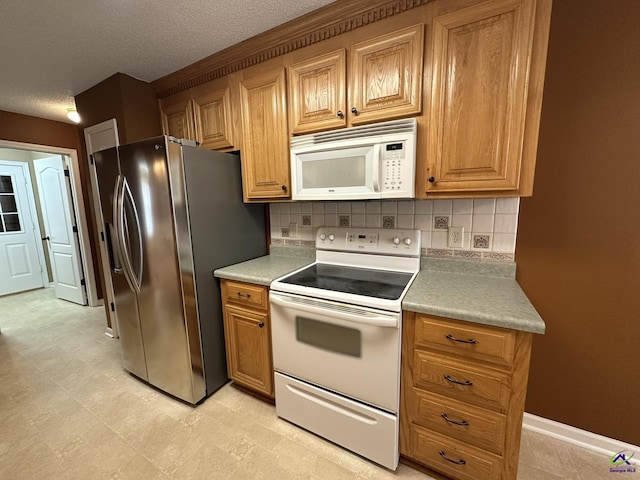 kitchen featuring white appliances, tasteful backsplash, light countertops, and a textured ceiling