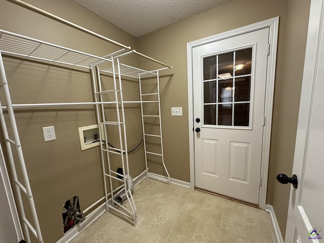 laundry area with baseboards, a textured ceiling, washer hookup, and laundry area