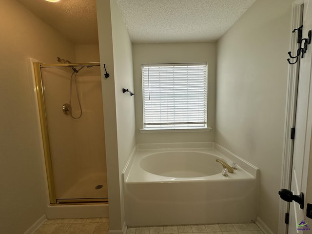 full bathroom with tile patterned flooring, a shower stall, and a textured ceiling