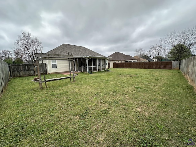 view of yard with a fenced backyard and a sunroom