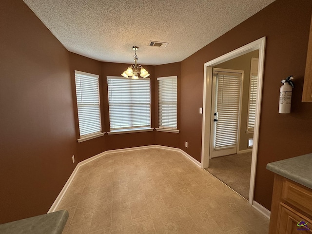 unfurnished dining area with a notable chandelier, baseboards, and visible vents