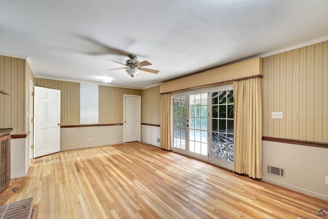 empty room with visible vents, baseboards, ceiling fan, ornamental molding, and wood finished floors