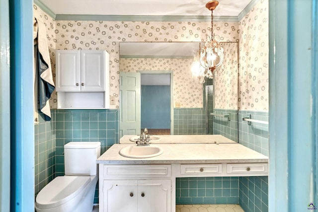 bathroom with vanity, a wainscoted wall, wallpapered walls, tile walls, and a chandelier