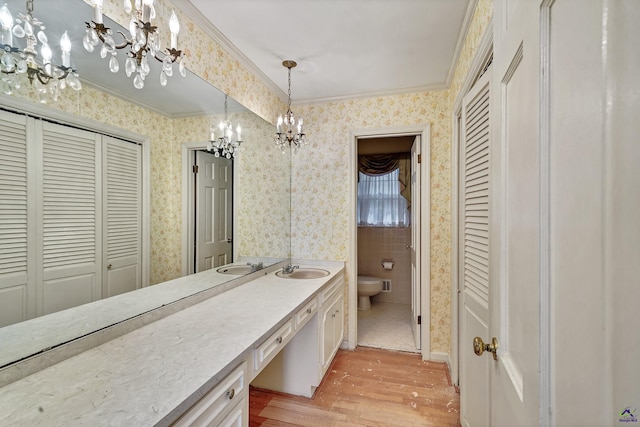 full bathroom with a closet, an inviting chandelier, and wallpapered walls