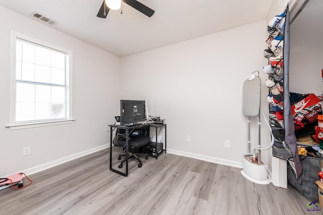 home office with visible vents, baseboards, wood finished floors, and a ceiling fan