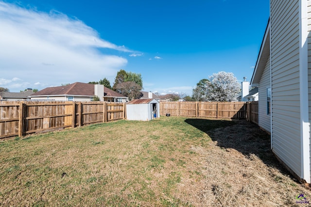 view of yard with an outbuilding, a fenced backyard, and a storage shed