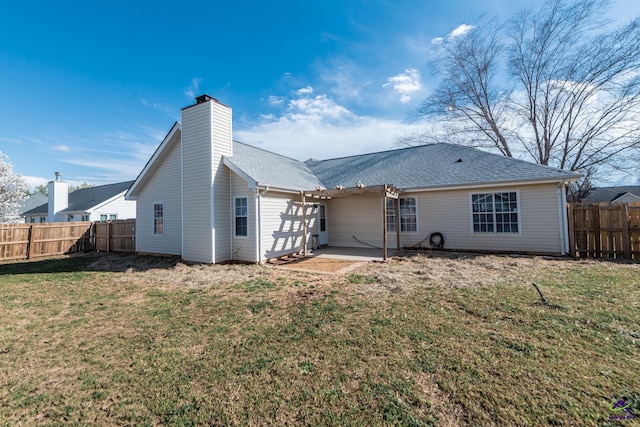 back of house with a yard, roof with shingles, a fenced backyard, and a patio area