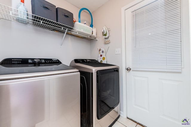 washroom with laundry area, light tile patterned floors, and washing machine and dryer