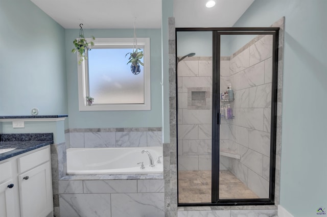 bathroom featuring a bath, a stall shower, and vanity