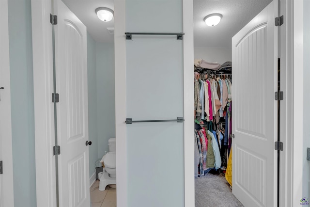 walk in closet with light tile patterned floors