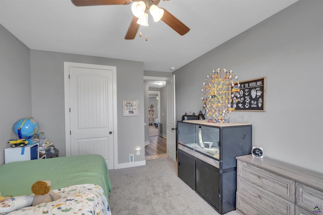 bedroom featuring baseboards, a ceiling fan, a closet, and light carpet