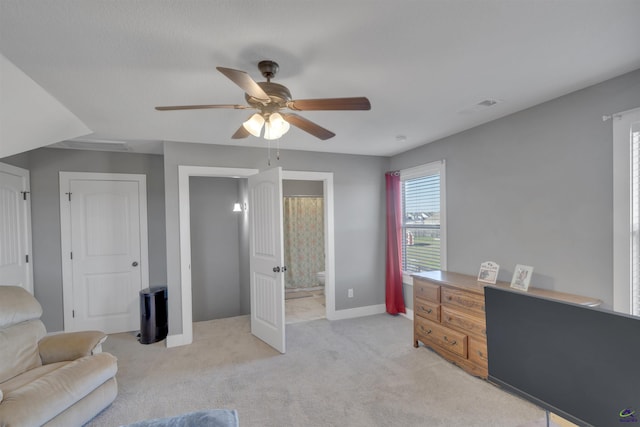 interior space featuring visible vents, light colored carpet, baseboards, and a ceiling fan