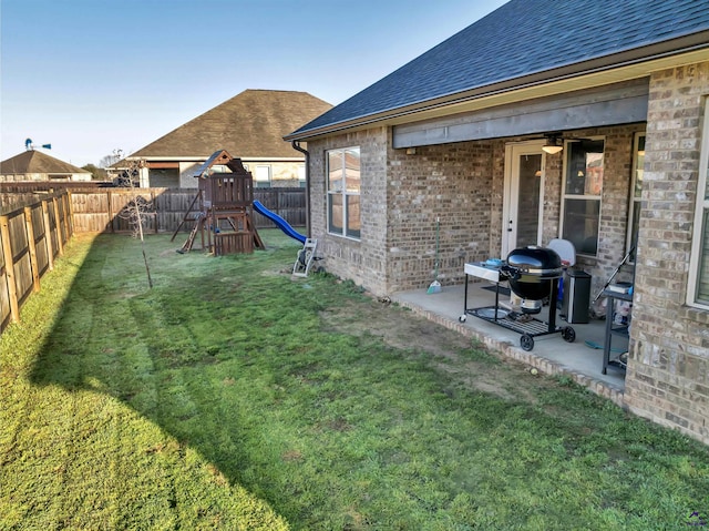 view of yard featuring a patio area, a playground, and a fenced backyard