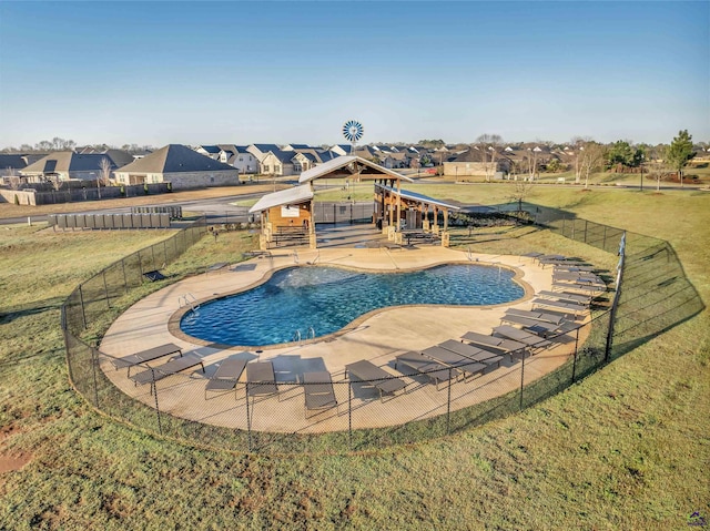 community pool with a patio area, a residential view, a yard, and a fenced backyard