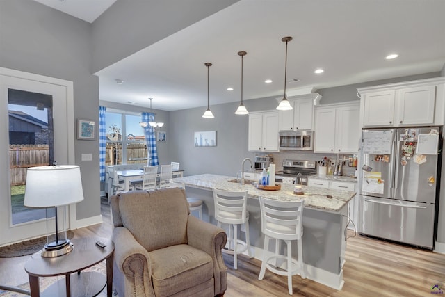 kitchen featuring stainless steel appliances, tasteful backsplash, light wood-style floors, and white cabinetry