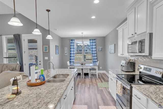 kitchen featuring a sink, backsplash, stainless steel appliances, white cabinets, and light wood finished floors