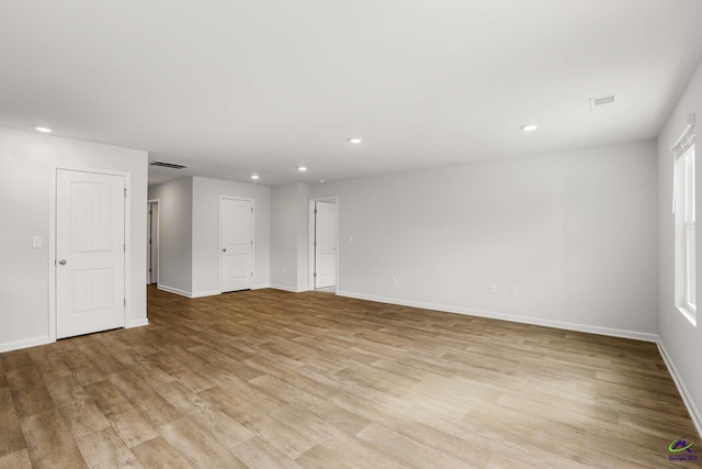 unfurnished room with recessed lighting, visible vents, light wood-style flooring, and baseboards