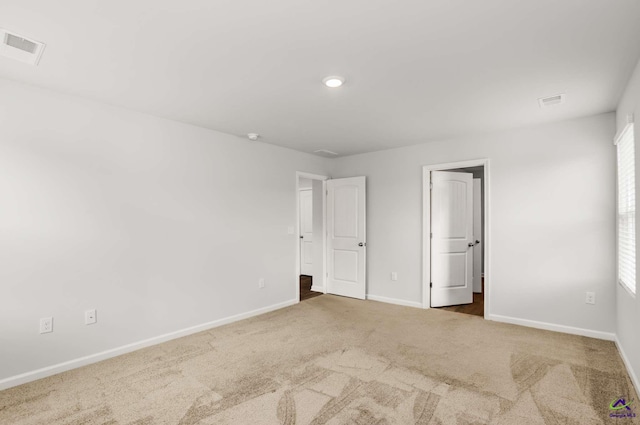 unfurnished bedroom featuring carpet flooring, visible vents, and baseboards