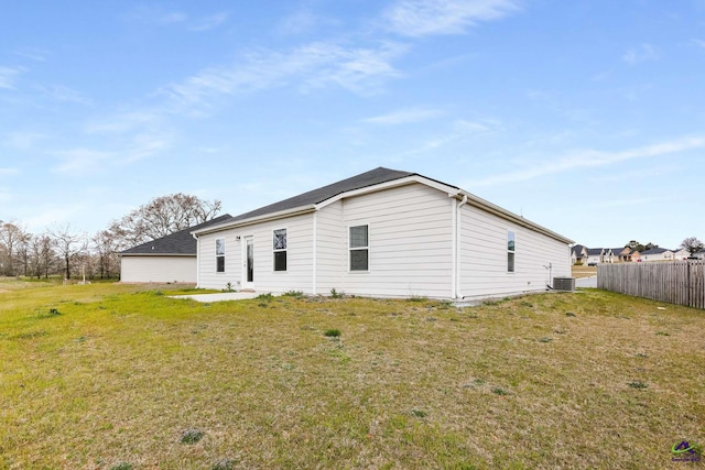 back of property featuring cooling unit, a yard, and fence