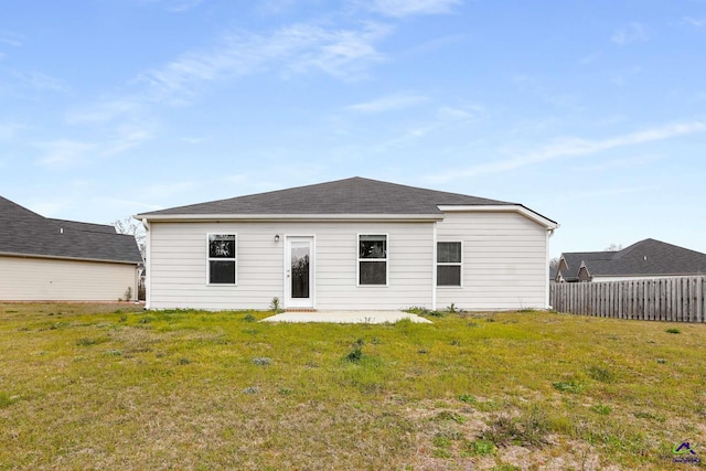 rear view of house with a yard and fence