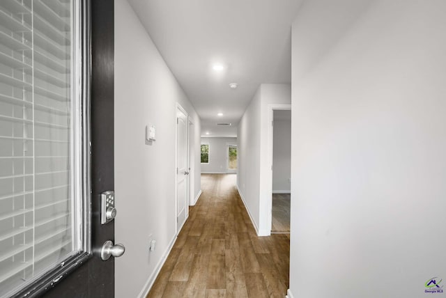 corridor with recessed lighting, baseboards, and wood finished floors