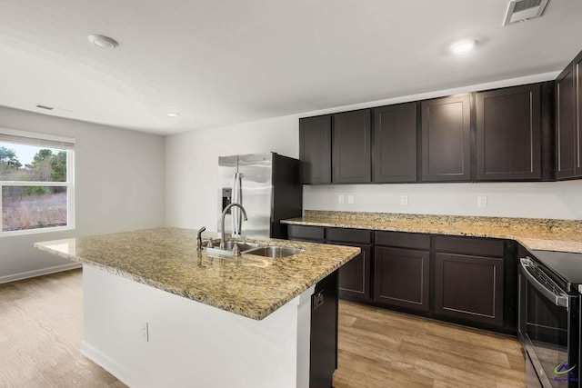 kitchen with visible vents, light wood-style flooring, stainless steel refrigerator with ice dispenser, a sink, and black range with electric cooktop