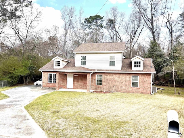 view of front of property with a front yard, a porch, a shingled roof, aphalt driveway, and brick siding