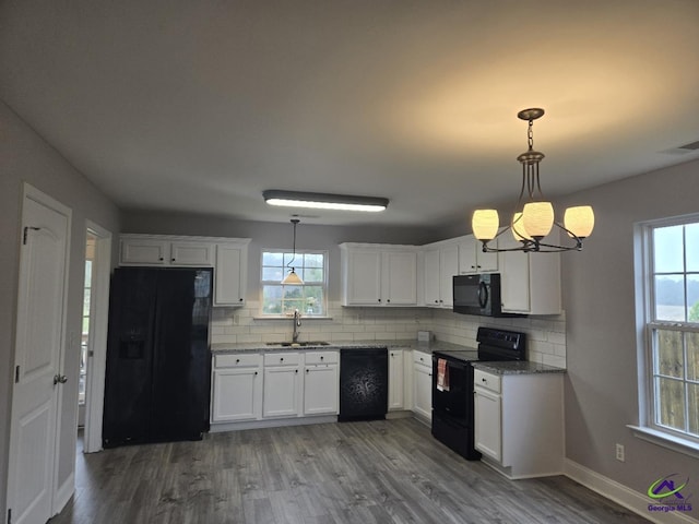 kitchen featuring tasteful backsplash, visible vents, black appliances, white cabinetry, and a sink