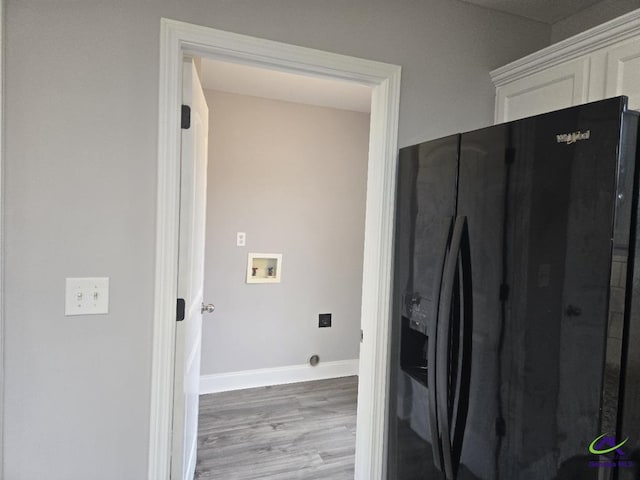 interior space with hookup for a washing machine, baseboards, wood finished floors, and laundry area