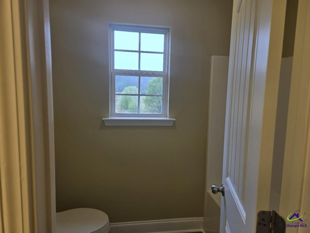 bathroom with toilet and baseboards