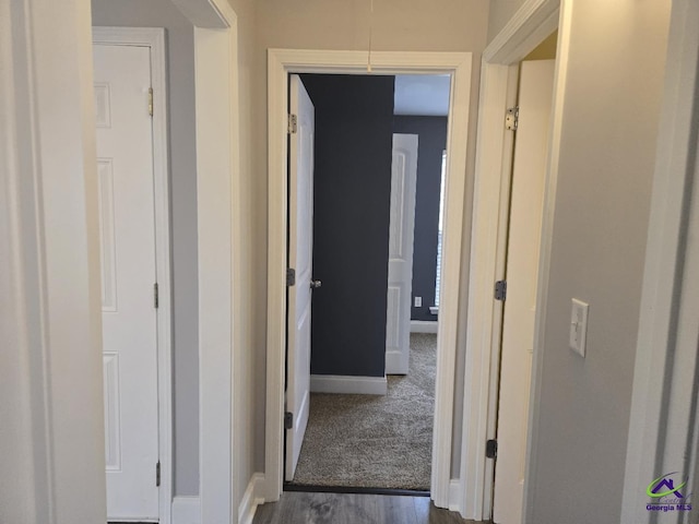 hall featuring baseboards and dark wood-style flooring