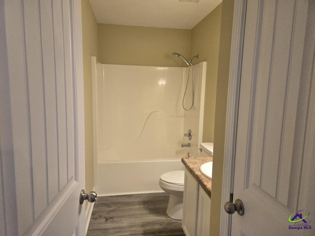 bathroom featuring bathtub / shower combination, toilet, wood finished floors, and vanity