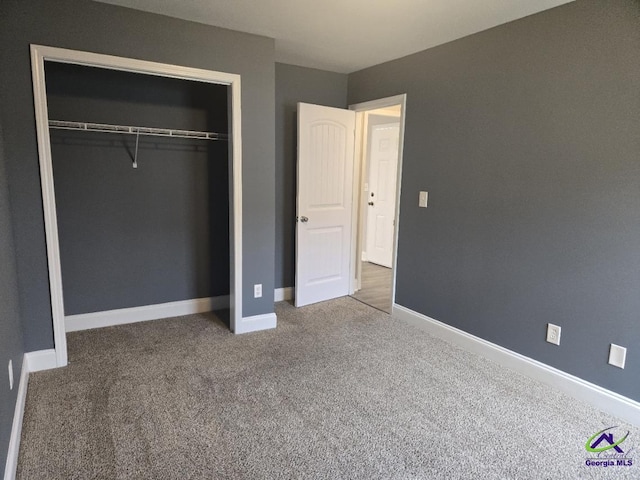 unfurnished bedroom with carpet, baseboards, and a closet