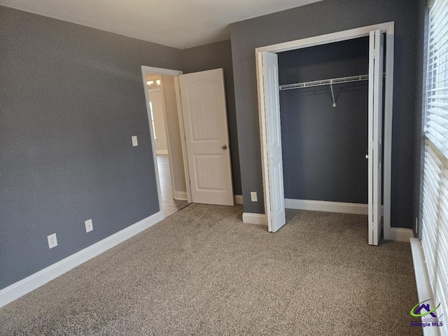 unfurnished bedroom featuring a closet, baseboards, and carpet floors