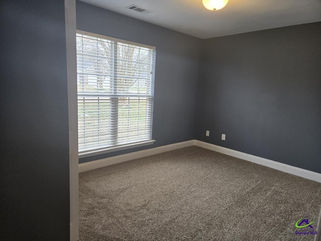 spare room with visible vents, carpet flooring, and baseboards