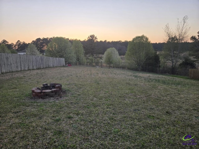 view of yard with fence and an outdoor fire pit