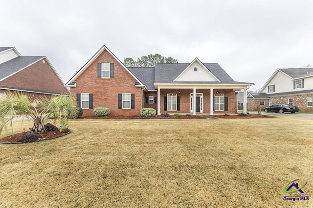 greek revival inspired property featuring brick siding, a porch, and a front lawn