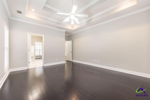 unfurnished room featuring visible vents, a tray ceiling, wood finished floors, crown molding, and ceiling fan