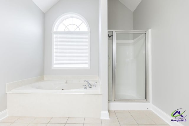 bathroom with tile patterned floors, lofted ceiling, a shower stall, baseboards, and a bath