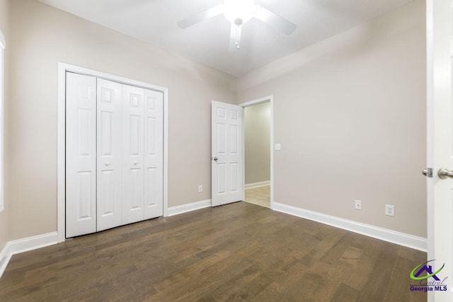 unfurnished bedroom with a closet, baseboards, wood finished floors, and a ceiling fan