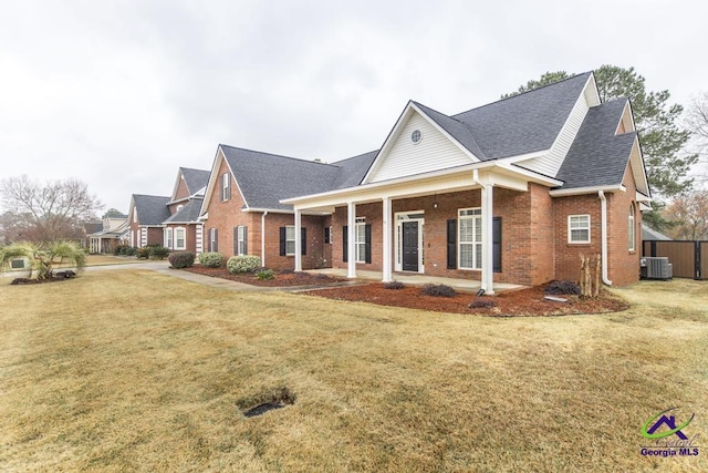 view of front of house featuring a front lawn, central AC unit, brick siding, and a shingled roof