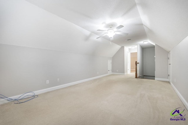 bonus room with visible vents, baseboards, lofted ceiling, light carpet, and a ceiling fan