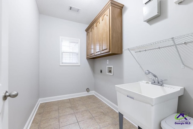 washroom featuring visible vents, washer hookup, a sink, cabinet space, and hookup for an electric dryer