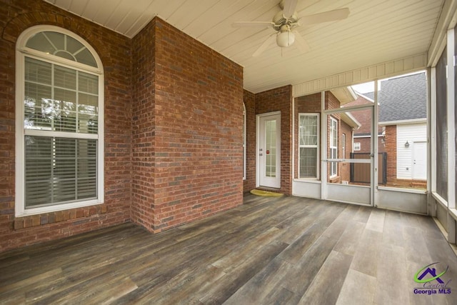 unfurnished sunroom with wood ceiling and a ceiling fan