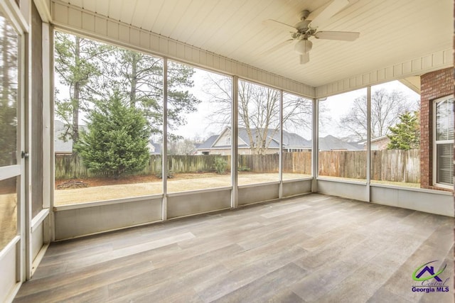 unfurnished sunroom with a ceiling fan