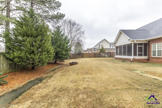 view of yard with fence and a sunroom