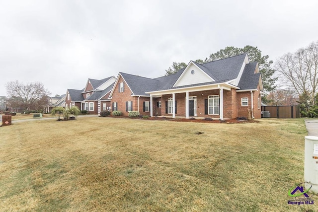 greek revival house featuring brick siding, central AC unit, and a front lawn