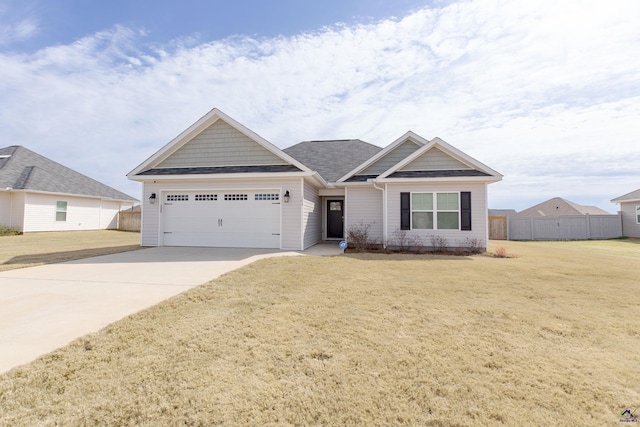 craftsman house featuring fence, driveway, roof with shingles, an attached garage, and a front lawn